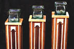 three architectural wooden candle platforms